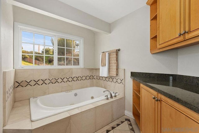 bathroom with tile patterned floors, vanity, and tiled tub