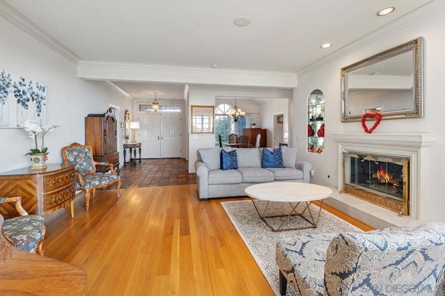 living room with hardwood / wood-style flooring, crown molding, and a chandelier