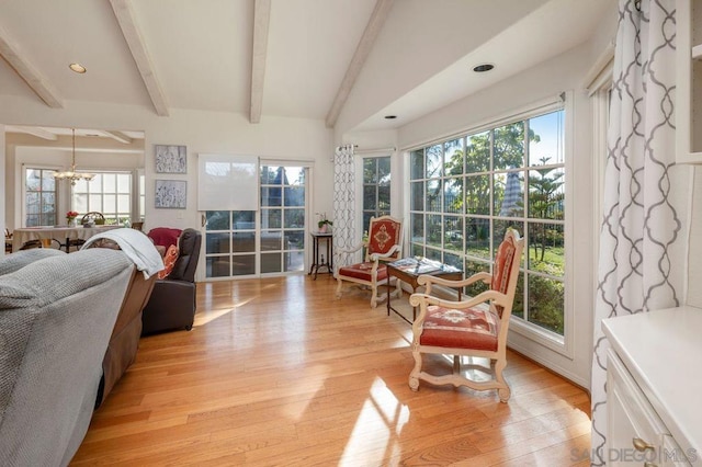 sunroom / solarium featuring beam ceiling and a chandelier