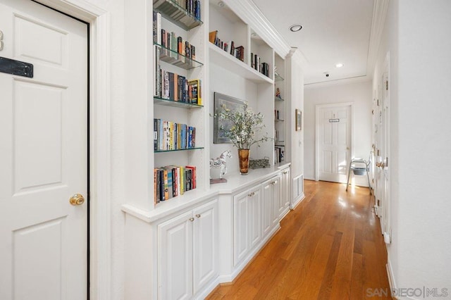 corridor with crown molding and light wood-type flooring