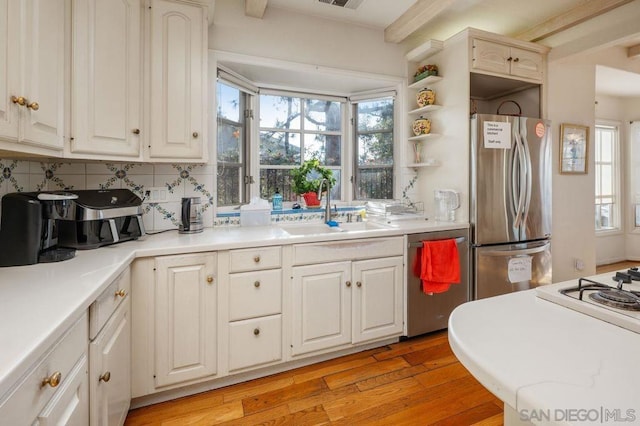 kitchen featuring sink, white cabinetry, light hardwood / wood-style flooring, appliances with stainless steel finishes, and plenty of natural light