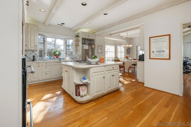 kitchen featuring white cabinetry, hanging light fixtures, light hardwood / wood-style flooring, and a kitchen island