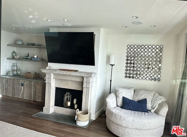 living room with a high end fireplace and dark hardwood / wood-style flooring