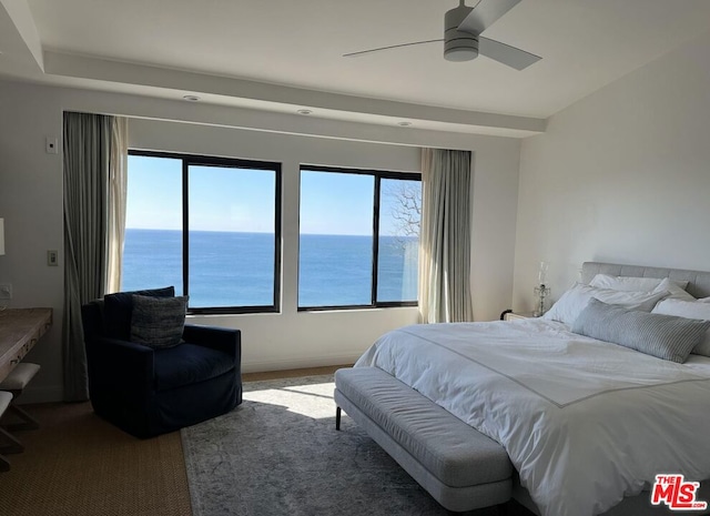 bedroom with a water view, ceiling fan, and carpet