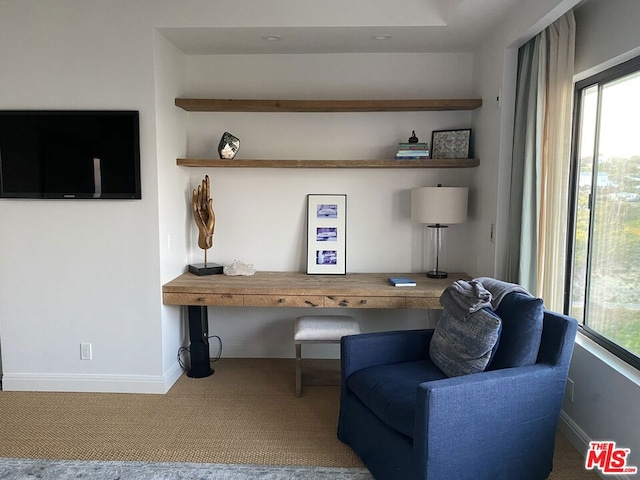 living area featuring plenty of natural light, carpet flooring, and built in desk