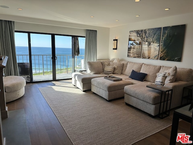 living room featuring a water view and dark hardwood / wood-style floors