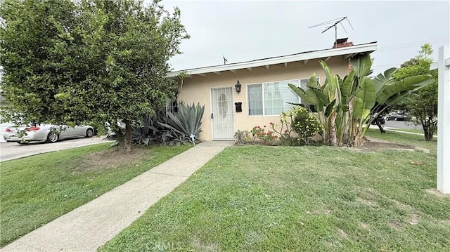 view of front of property with stucco siding and a front lawn