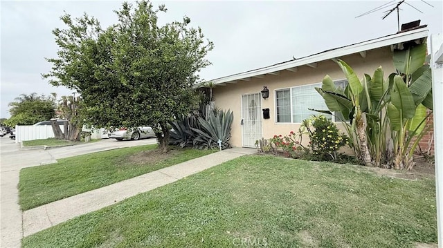 view of front facade with a front lawn, concrete driveway, and stucco siding