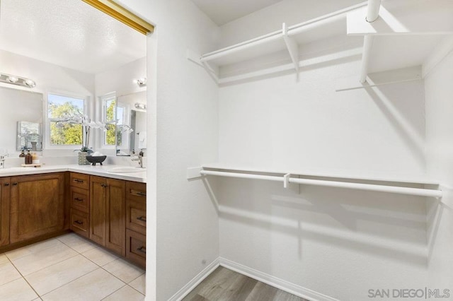 walk in closet featuring light tile patterned flooring and sink