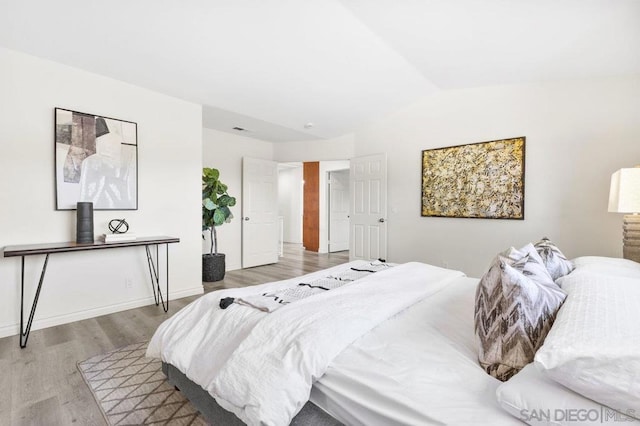 bedroom featuring wood-type flooring and lofted ceiling