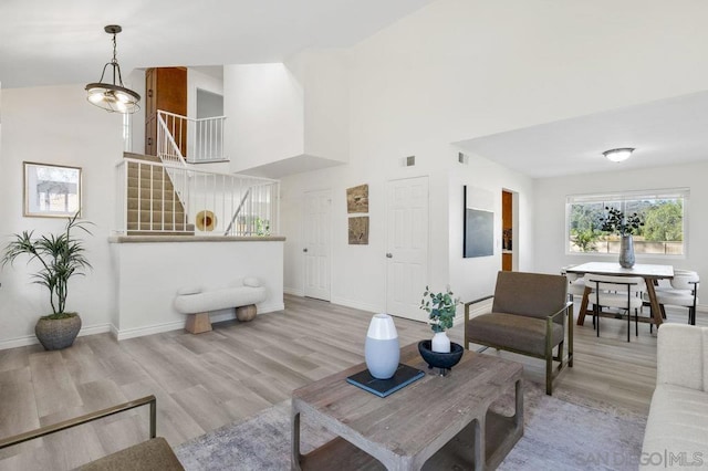 living room featuring a towering ceiling and light hardwood / wood-style flooring