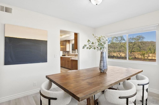 dining space featuring sink and light hardwood / wood-style flooring