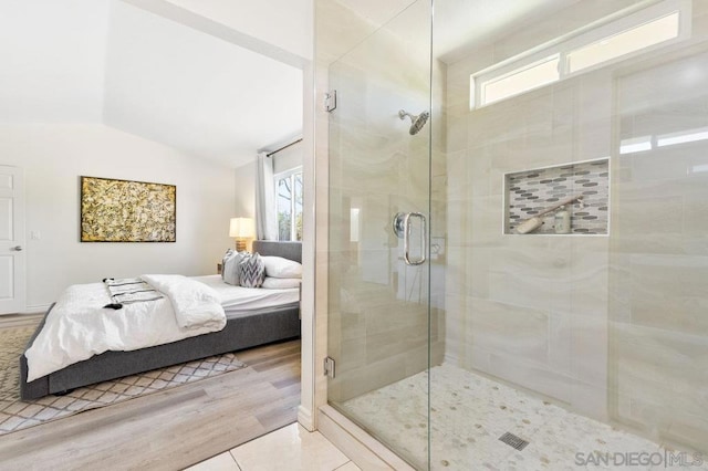 bathroom with an enclosed shower, wood-type flooring, vaulted ceiling, and a healthy amount of sunlight