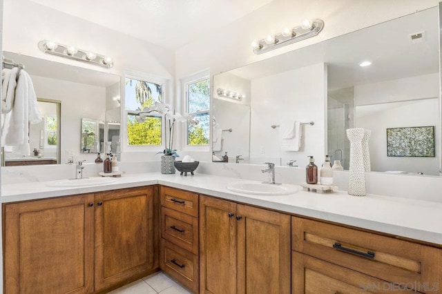 bathroom with tile patterned flooring, vanity, and a shower with door