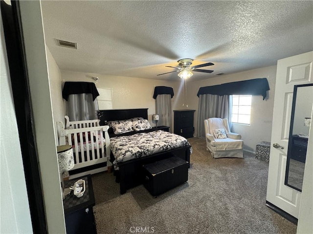 carpeted bedroom featuring ceiling fan and a textured ceiling