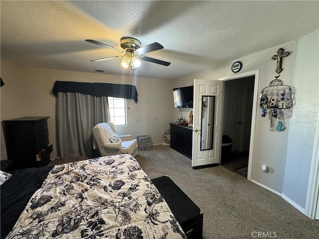 bedroom with ceiling fan, dark carpet, and a textured ceiling