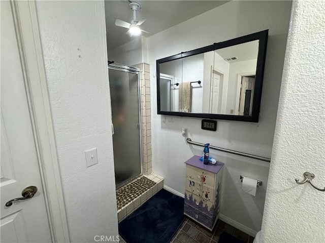 bathroom with ceiling fan, a shower with shower door, and tile patterned flooring