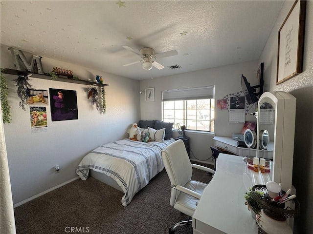 bedroom with ceiling fan, carpet floors, and a textured ceiling