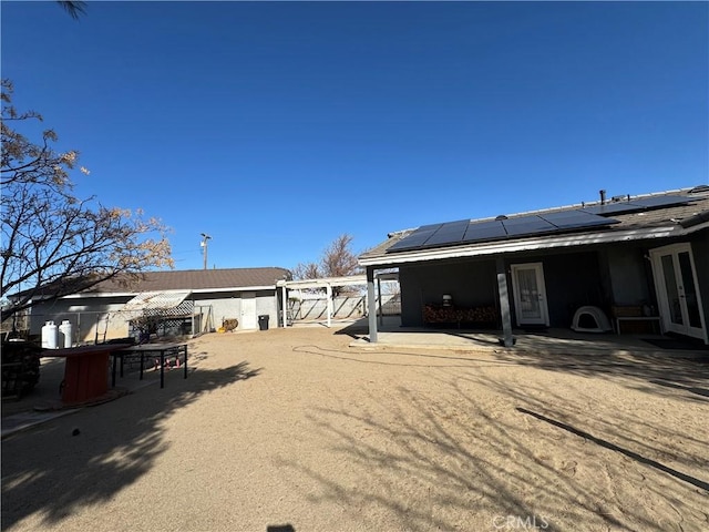 back of property featuring a patio and solar panels