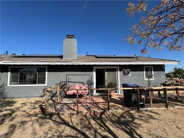 rear view of house with a patio and solar panels