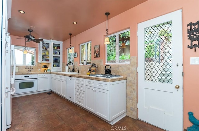 kitchen featuring white cabinetry, sink, hanging light fixtures, ceiling fan, and white appliances