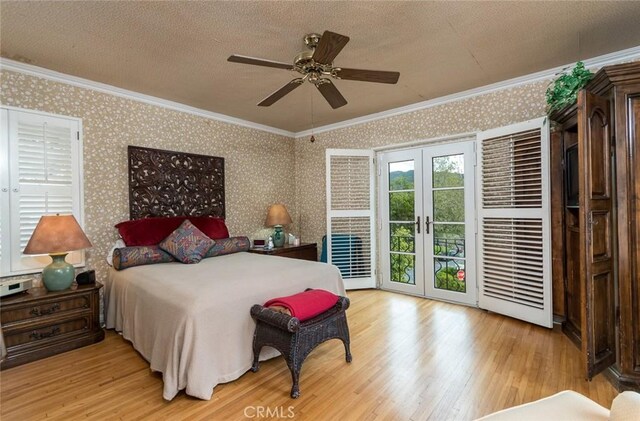 bedroom featuring french doors, ornamental molding, a textured ceiling, and access to outside