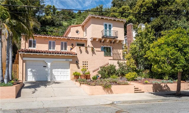 mediterranean / spanish home featuring a garage and a balcony