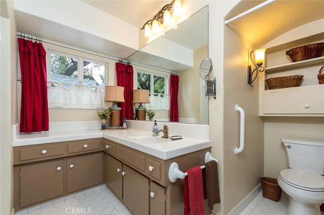 bathroom featuring tile patterned flooring, vanity, curtained shower, and toilet