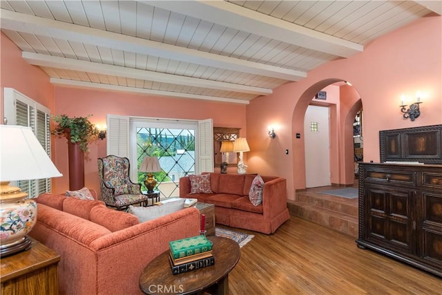 living room featuring beamed ceiling, light hardwood / wood-style flooring, and wooden ceiling