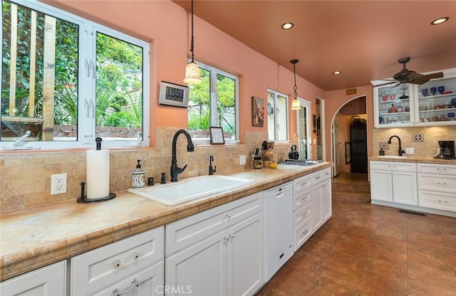 kitchen featuring hanging light fixtures, sink, white cabinets, and white dishwasher