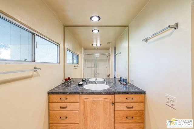 bathroom with vanity and a shower with shower door