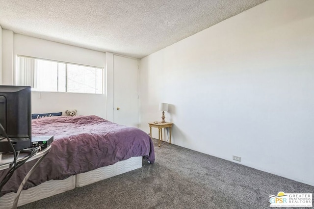 bedroom featuring dark carpet and a textured ceiling