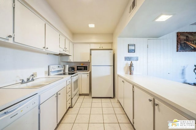 kitchen featuring white cabinetry, sink, white appliances, and light tile patterned floors