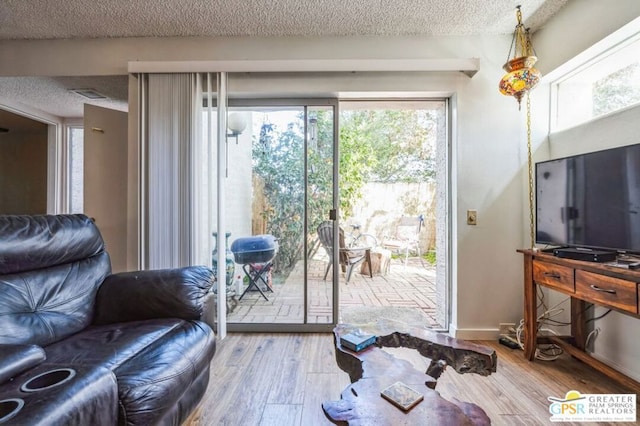 doorway to outside with hardwood / wood-style floors and a textured ceiling