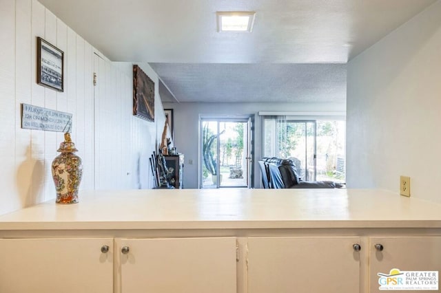 kitchen featuring white cabinetry, a textured ceiling, and kitchen peninsula