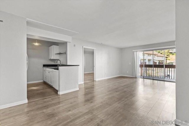 kitchen featuring sink, wood-type flooring, and white cabinets