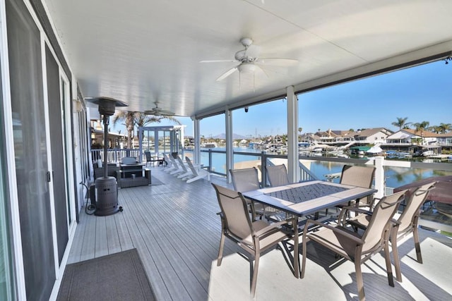 wooden deck with a water view and ceiling fan