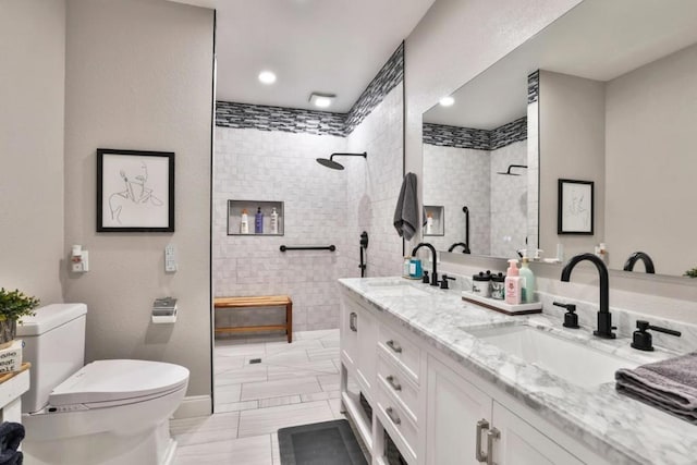 bathroom featuring vanity, tiled shower, and toilet