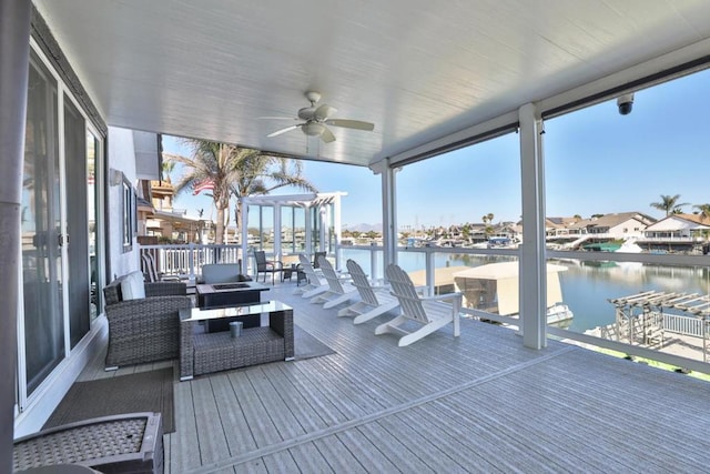 deck featuring an outdoor hangout area, ceiling fan, and a water view