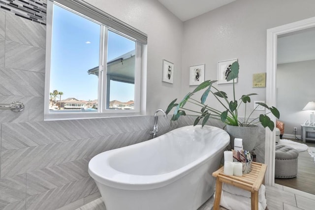 bathroom featuring a bathing tub and tile walls