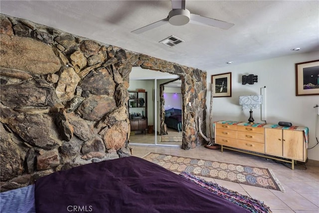 tiled bedroom featuring ceiling fan