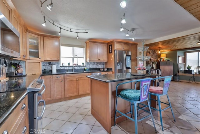 kitchen with stainless steel appliances, a center island, sink, and a wealth of natural light