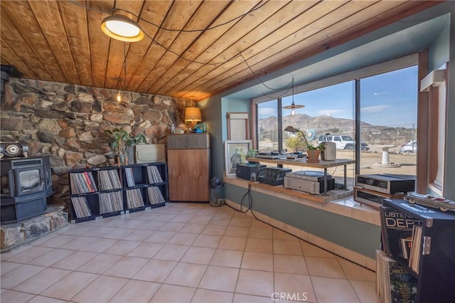 interior space with wooden ceiling, a mountain view, and a wood stove