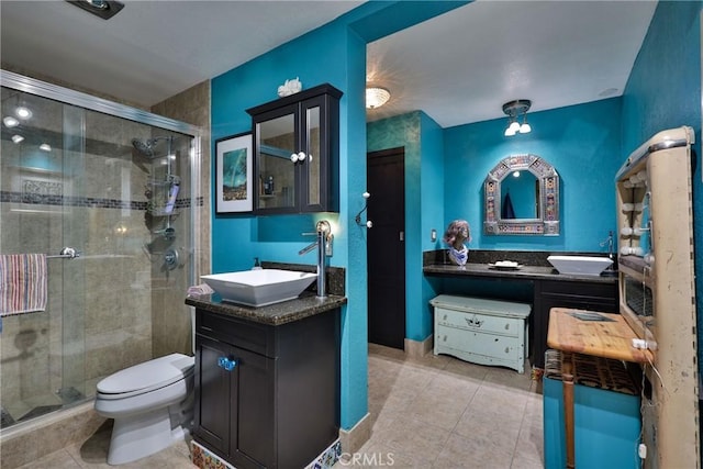 bathroom with vanity, toilet, an enclosed shower, and tile patterned flooring