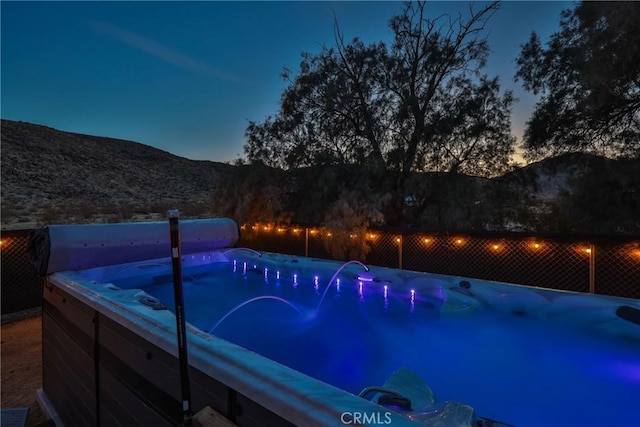 pool at dusk featuring a mountain view