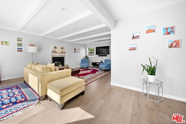 living room with beam ceiling and light hardwood / wood-style flooring