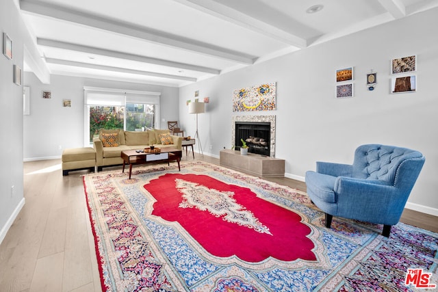 living room with wood-type flooring, a fireplace, and beam ceiling