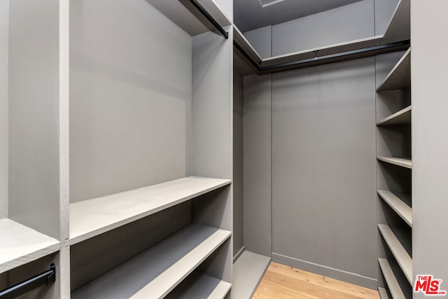 walk in closet with light wood-type flooring