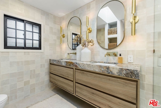 bathroom featuring vanity and tile walls