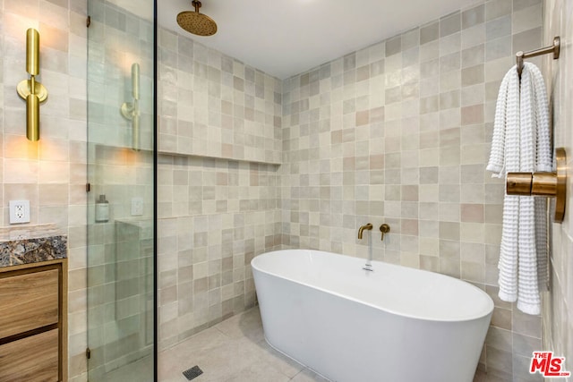 bathroom with tile walls, vanity, tile patterned floors, and separate shower and tub